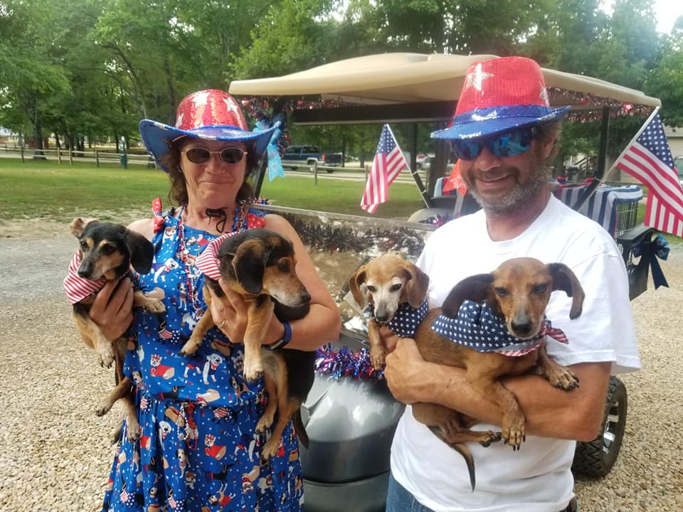 Jerry and Rebecca Early holding 4 dogs while wearing patriotic gear